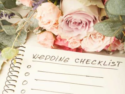 Wedding checklist with copy space and rose bouquet on the white desktop. Marriage planner concept, copy space.